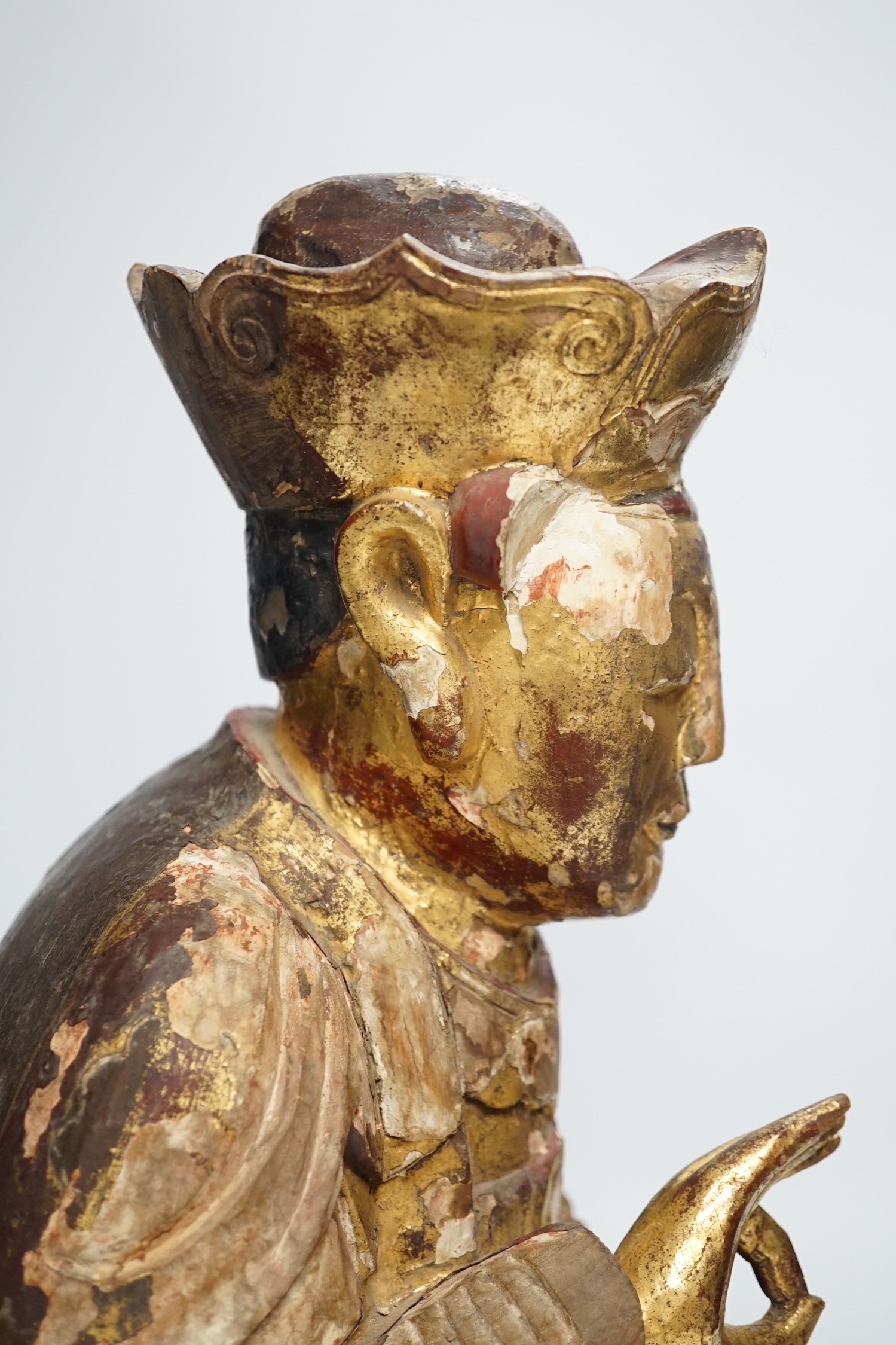 A Chinese gilt lacquered wooden figure of Buddha, possibly Yuan to Ming, 42cm high. Condition - poor to fair, losses to lacquer overall
